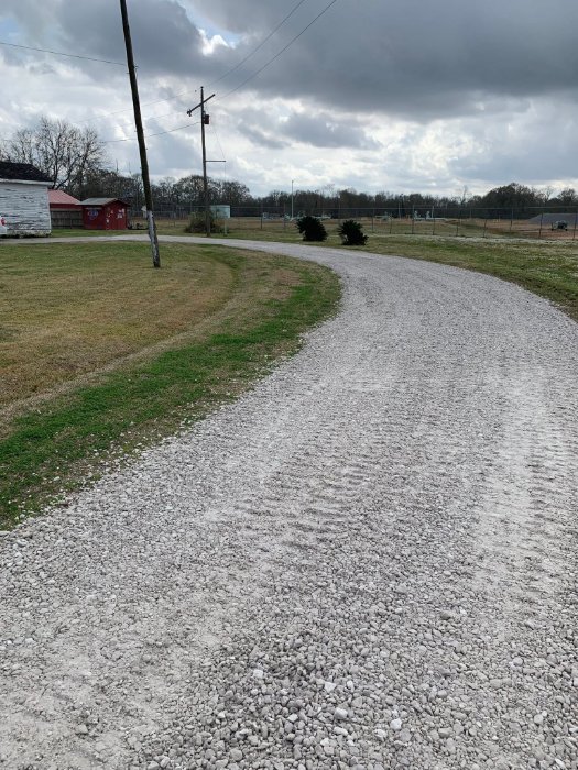 Curving limestone driveway across a pasture